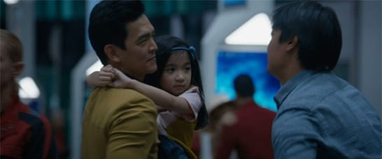 Hikaru Sulu rushes over to his family, lifts up his daughter and puts an arm around his husband.